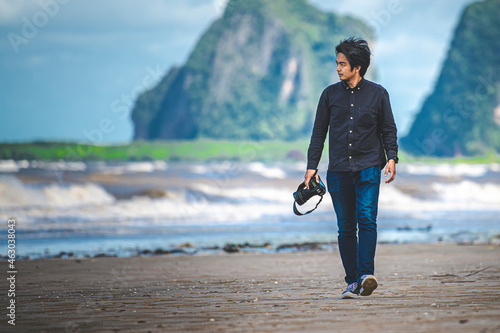 The photographer walking on the beach.