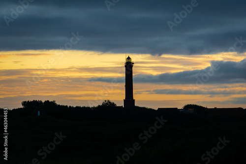 lighthouse at colorful yellow sunset