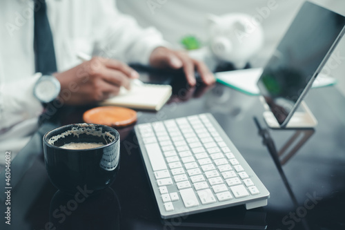 Business man working at home and typing on laptop computer keyboard with smartphone on wooden table. Work online. Technology laptop concept. 