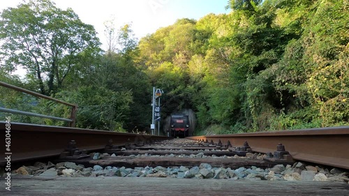 Ancient steam train comes out of the tunnel, shot from below.