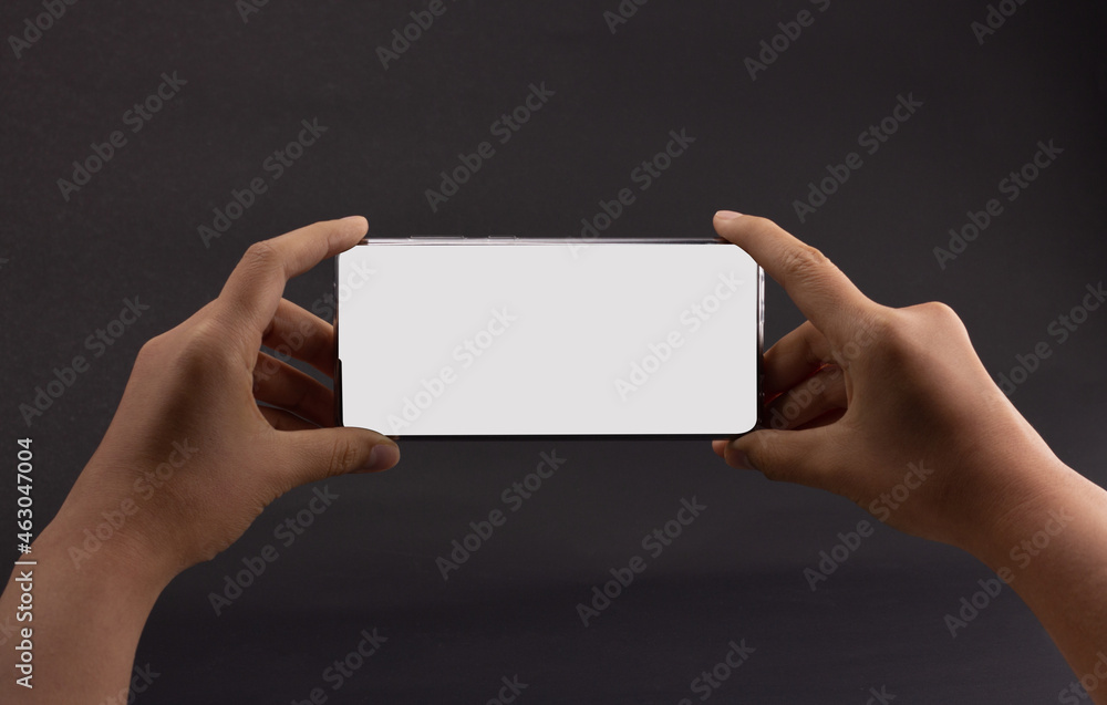 2 hand holding smartphone in horizontal isolated on black background. Customers can put ads, website pages or information that they want to be displayed on the phone screen. 2 hand holding smartphone in horizontal isolated on black background. Customers can put ads, website pages or information that they want to be displayed on the phone screen.