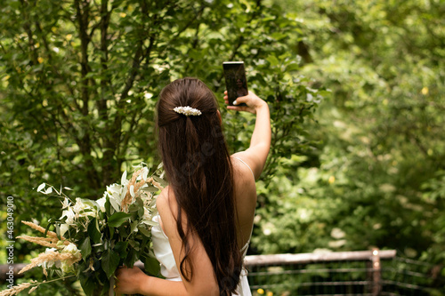 Beautiful bride making selfie before wedding outside. photo