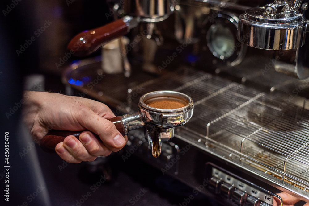 Closeup image of male hands pouring milk and preparing fresh cappuccino, coffee artist and preparation concept, morning coffee