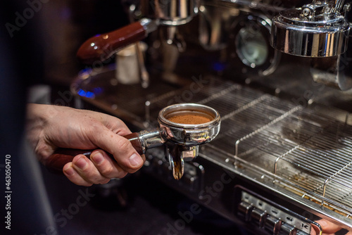 Closeup image of male hands pouring milk and preparing fresh cappuccino, coffee artist and preparation concept, morning coffee