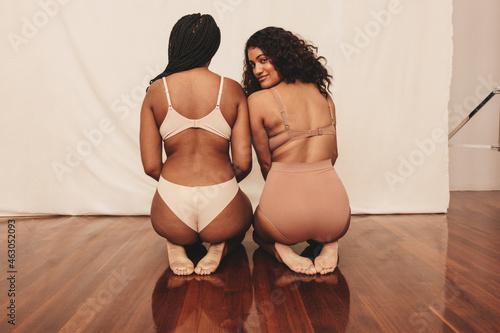 Fototapeta Two confident young women kneeling in underwear