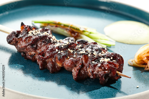 Bild auf Leinwand Food in Japanese restaurant - skewer yakitori with beef and teriyaki sauce