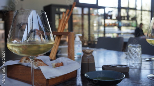 A glass of white wine and Snacks at the luxury restaurant table. Olive oil and bread in the background