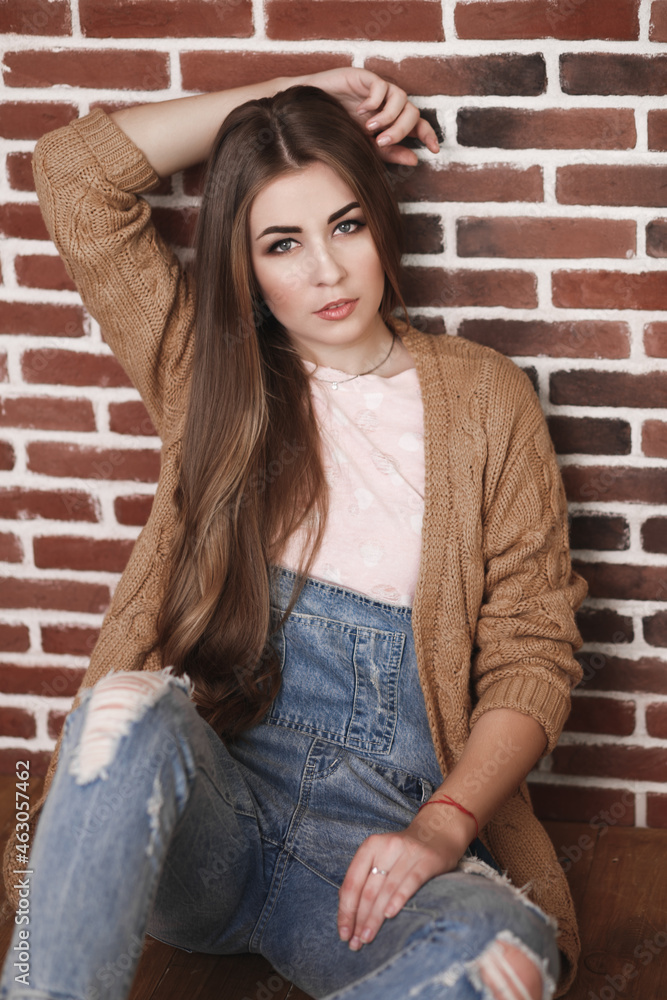 A young beautiful woman with long hair in a denim jumpsuit A young beautiful woman with long hair in a denim jumpsuit