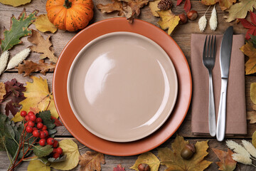 Festive table setting with autumn decor on wooden background, flat lay
