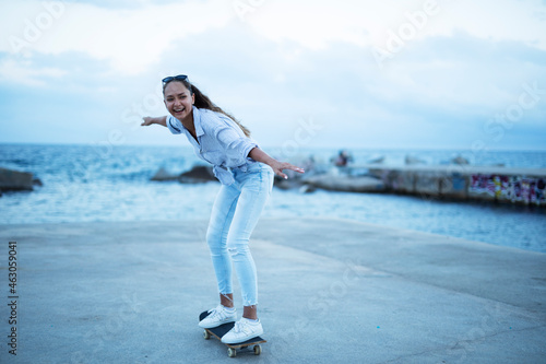 Fashion woman with skateboard. Young happy girl enjoy outside