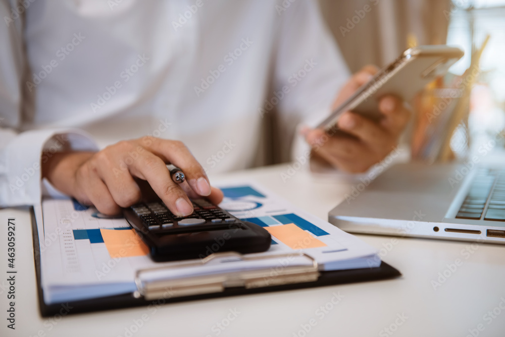 Fototapeta premium Business and financial concepts about office work. Analysts discuss business with a calculator as a tool.