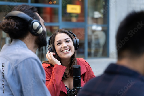 Young professional women with headphones and microphone outdoors while doing an interview.  photo