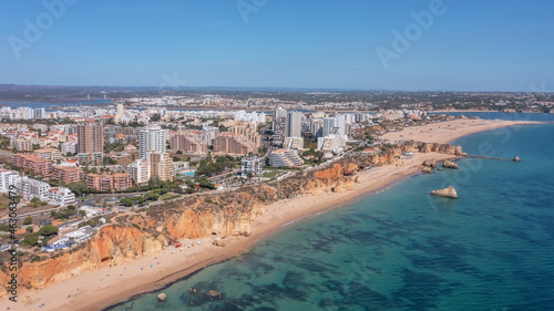 Aerial view of the wide and crowded Portuguese famous Rocha beach in Portimao, Algarve, Portugal. Drone shot
