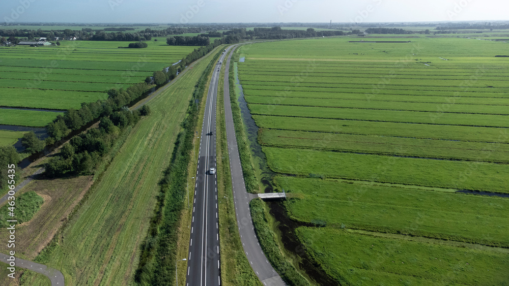 Aerial view of road leading through meadow landscape in the netherlands