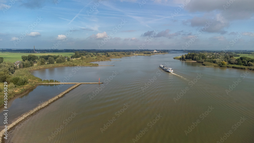 Inland container barge on River Lek aerial view near the village of Bergambacht, South Holland, Netherlands Inland container barge on River Lek aerial view near the village of Bergambacht, South Holland, Netherlands