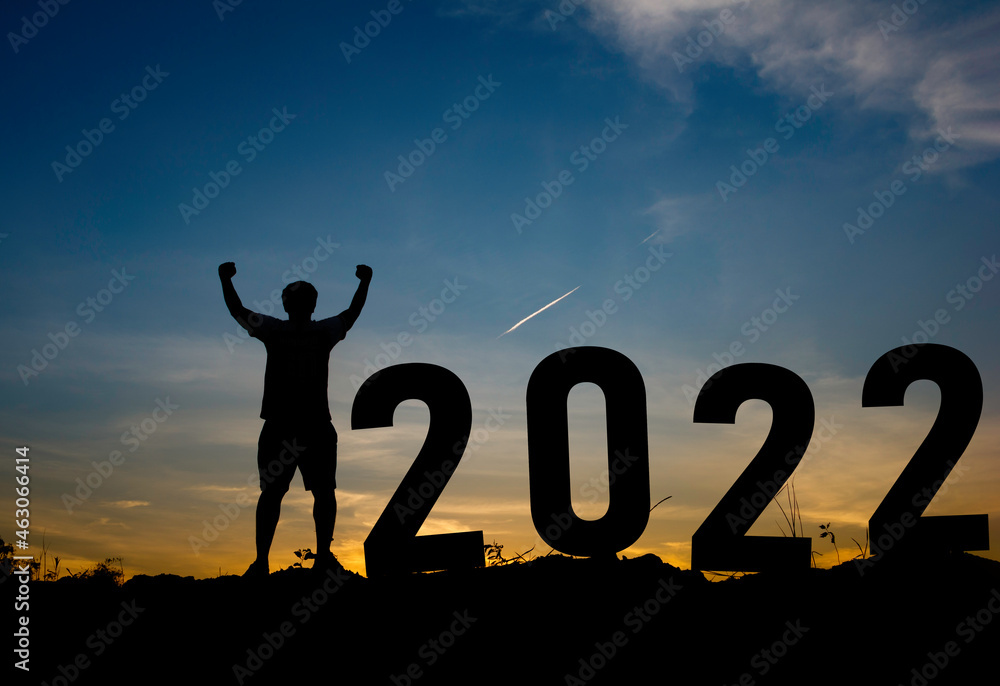 Happy new year Silhouette sunset background.A man standing next to 2022.new year,success,2022, Photo Silhouette and new year concept idea. Happy new year Silhouette sunset background.A man standing next to 2022.new year,success,2022, Photo Silhouette and new year concept idea.