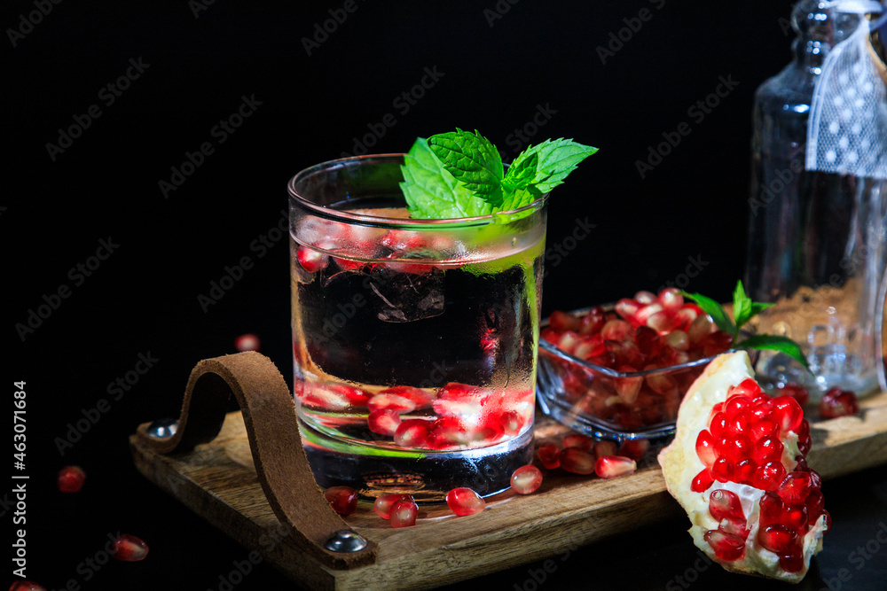 two colorful summer cocktails with pomegranate and mint on a black table two colorful summer cocktails with pomegranate and mint on a black table