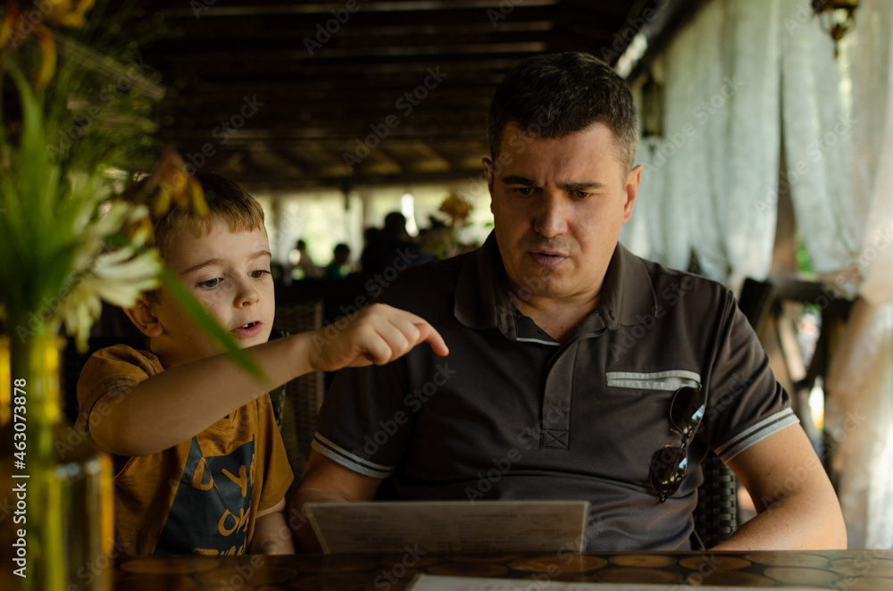 father and son eat in a beautiful cafe on Father's Day