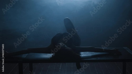 Silhouette of a sexy girl dancing an erotic sensual dance in blue smoke.
