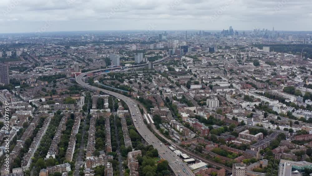 Aerial panoramic view of multilane highway winding through urban neighbourhood. Skyline with modern skyscrapers in background. London, UK Aerial panoramic view of multilane highway winding through urban neighbourhood. Skyline with modern skyscrapers in background. London, UK