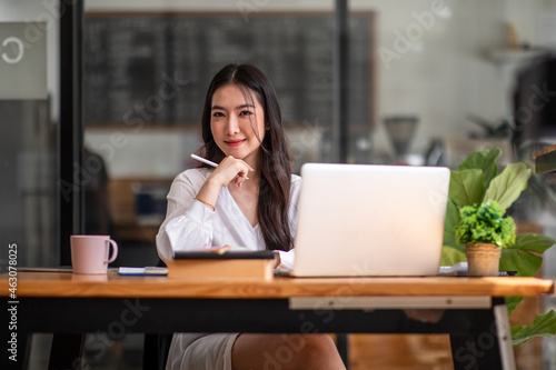 Shot of an Asian young business Female working on laptop computer in her workstation.Portrait of Business people employee freelance online report marketing e-commerce telemarketing concept.