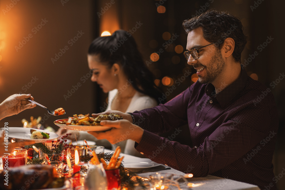 holidays, party and celebration concept - happy man with friends having christmas dinner at home - obrazy, fototapety, plakaty 