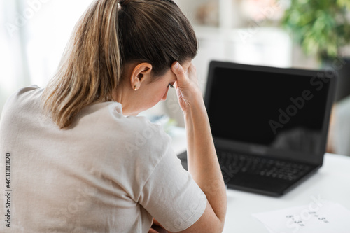 distant education, remote job and health concept - tired female teacher with laptop computer having headache at home office