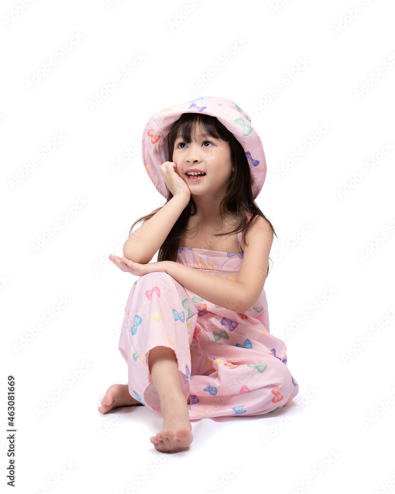 Beautiful Asian girl smiling brightly in a pink dress and hat sits relaxing posting for fashion shoot on white background. Happy, healthy, bright cute boy Beautiful Asian girl smiling brightly in a pink dress and hat sits relaxing posting for fashion shoot on white background. Happy, healthy, bright cute boy