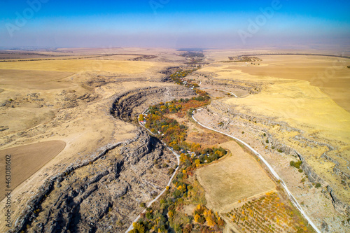 A canyon in the middle of a dry, yellowed autumn steppe. Aerial View