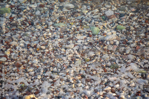 Background of wet stones on a beach surface near water 