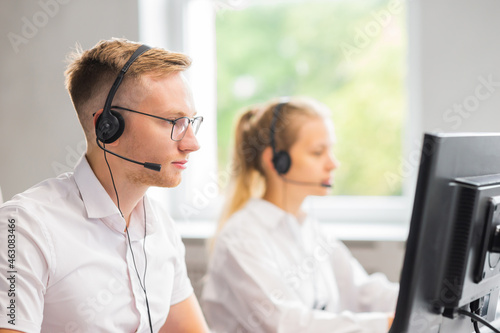 Diverse team of young professionals is working in the phone support office. Working day of sales managers in the call center. Business, telephone consulting and problem solving.