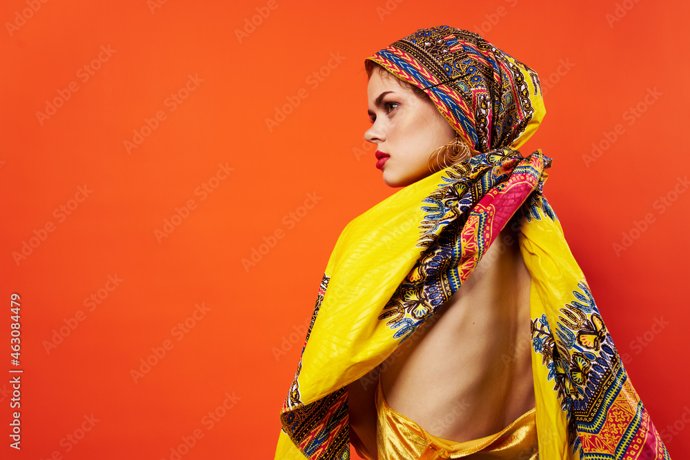 Obraz premium cheerful woman ethnicity multicolored headscarf makeup glamor red background