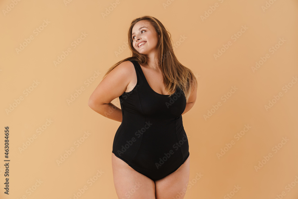 Young woman wearing swimsuit smiling and looking aside Young woman wearing swimsuit smiling and looking aside