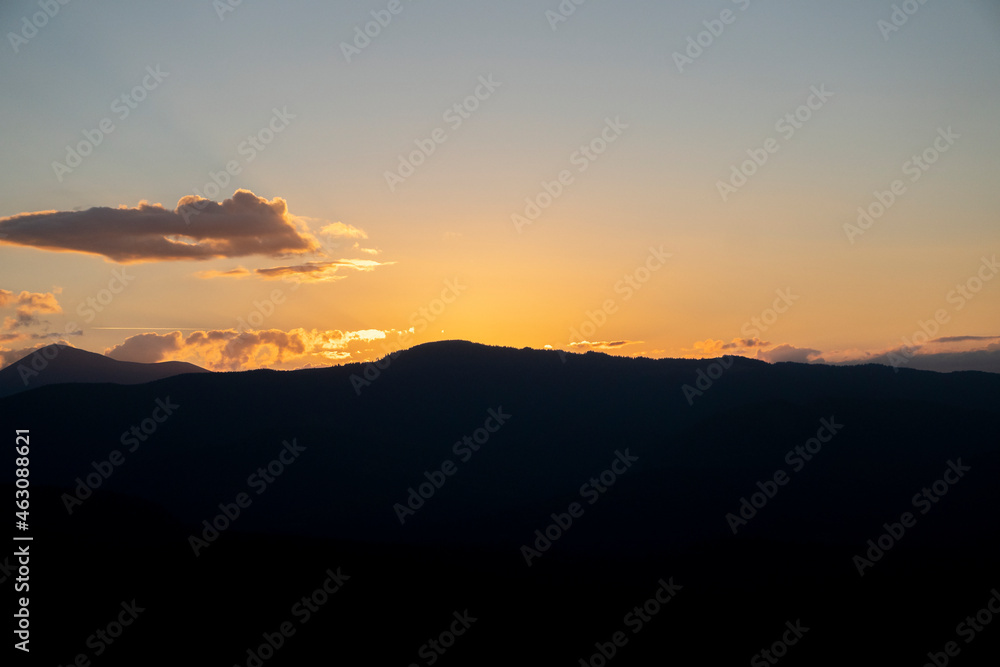 Colorful morning silhouettes of coniferous forest Beautiful sunset in the mountains