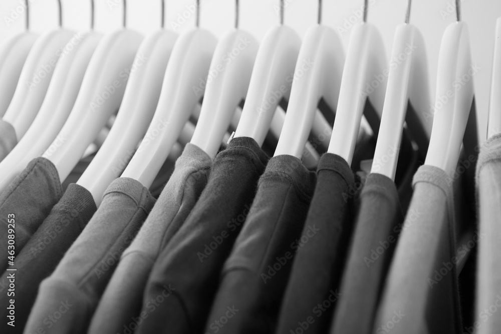 Collection of gray color t-shirts hanging on clothes hanger Collection of gray color t-shirts hanging on clothes hanger