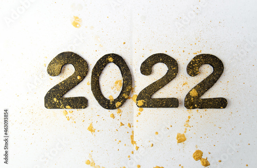 black numbers 2022 on the background of golden splashes. happy new year 2022