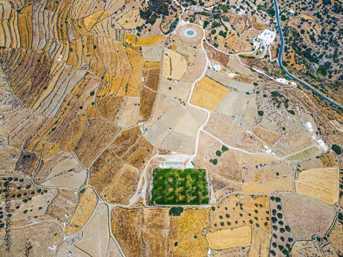 Aerial view on a green football field during drought on sifnos island, Greece