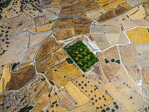 Aerial view on a green football field during drought on sifnos island, Greece