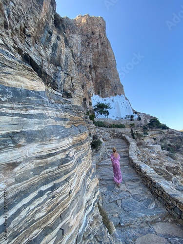 Woman following a stairs to visiting Orthodox monastry of Panagia Hozoviotissa on amorgos island, Greece, Cyclades