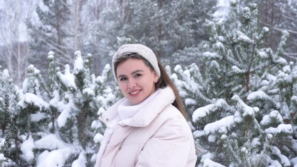 Portrait of a beautiful happy young woman in a snowy forest. Slow motion Portrait of a beautiful happy young woman in a snowy forest. Slow motion