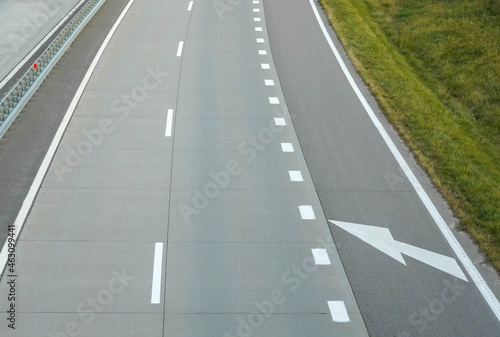 Photo of a gray road with white road markings