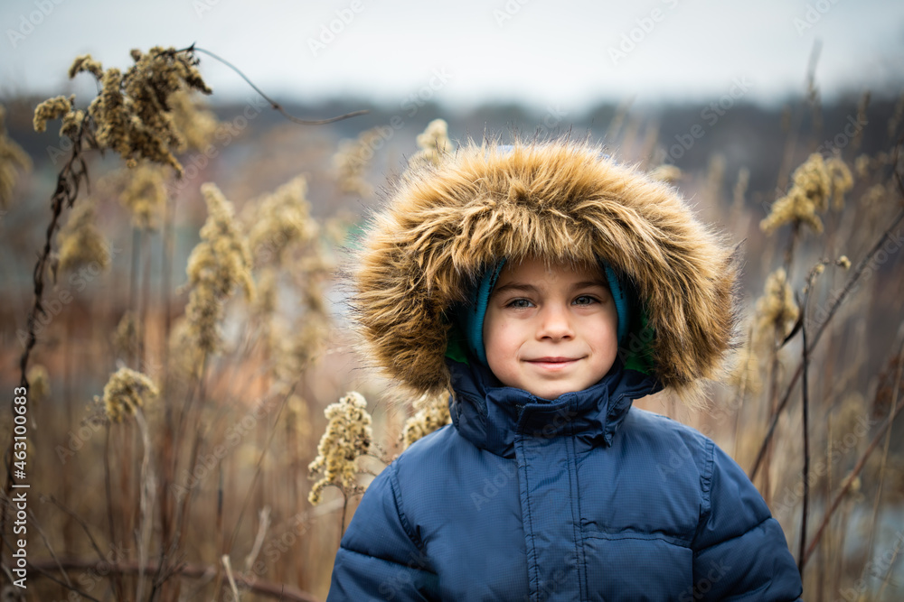 Portrait of preschool boy in warm coat with hood in winter outdoors Portrait of preschool boy in warm coat with hood in winter outdoors