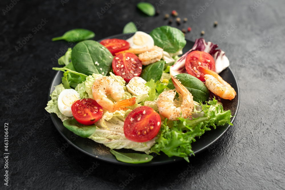 Fresh seafood salad. Grilled shrimp, fresh vegetable salad and egg. Fried shrimps. Healthy food on stone background