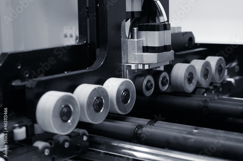 The image of the feed rollers of a woodworking machine.