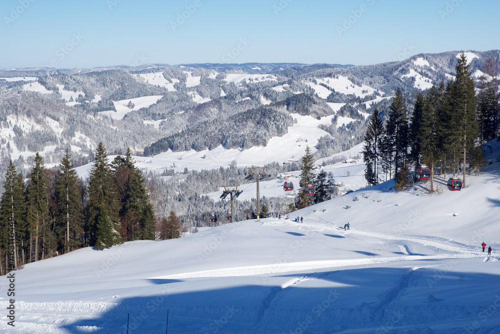 OBERSTAUFEN, GERMANY - 29 DEC, 2017: Beautiful view of the snowy winter resort Oberstaufen with a ski slope in the foreground in the Bavarian Alps