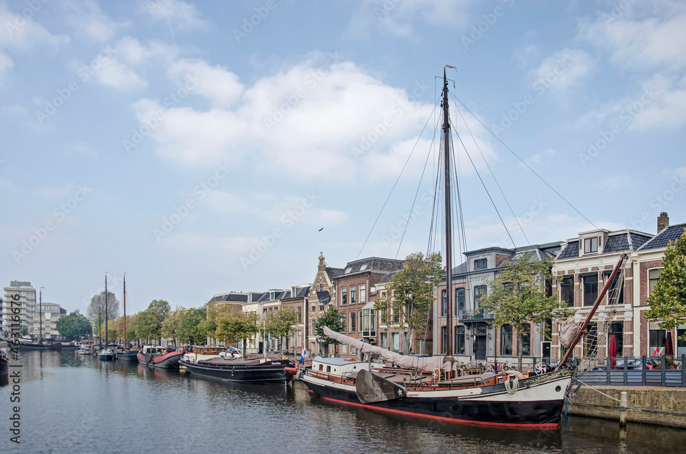 Leeuwarden, The Netherlands, October 10, 2021: Zuiderstadsgracht canal, lined with historic boats as well as houses, one of them the birthplace of Mata Hari