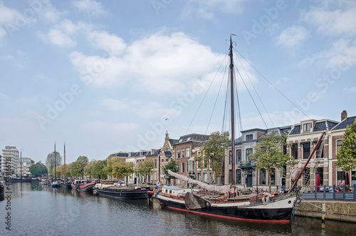 Leeuwarden, The Netherlands, October 10, 2021: Zuiderstadsgracht canal, lined with historic boats as well as houses, one of them the birthplace of Mata Hari