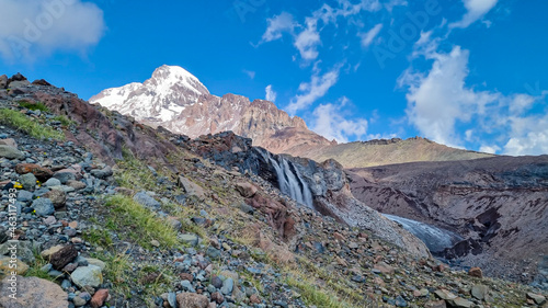 A cloudless view on Mount Kazbeg in Caucasus, Georgia. There slopes are barren and stony below the snow-capped peak and the Gergeti Glacier. Tranquillity. Natural remedy. Massive glacier foot