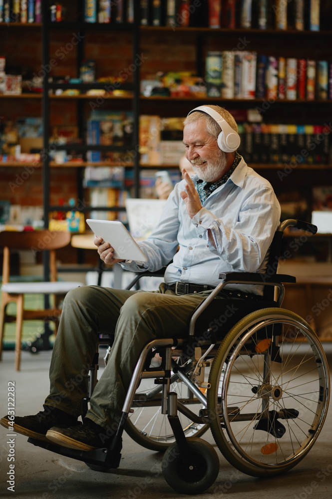 Adult disabled man in wheelchair listen to music - obrazy, fototapety, plakaty 