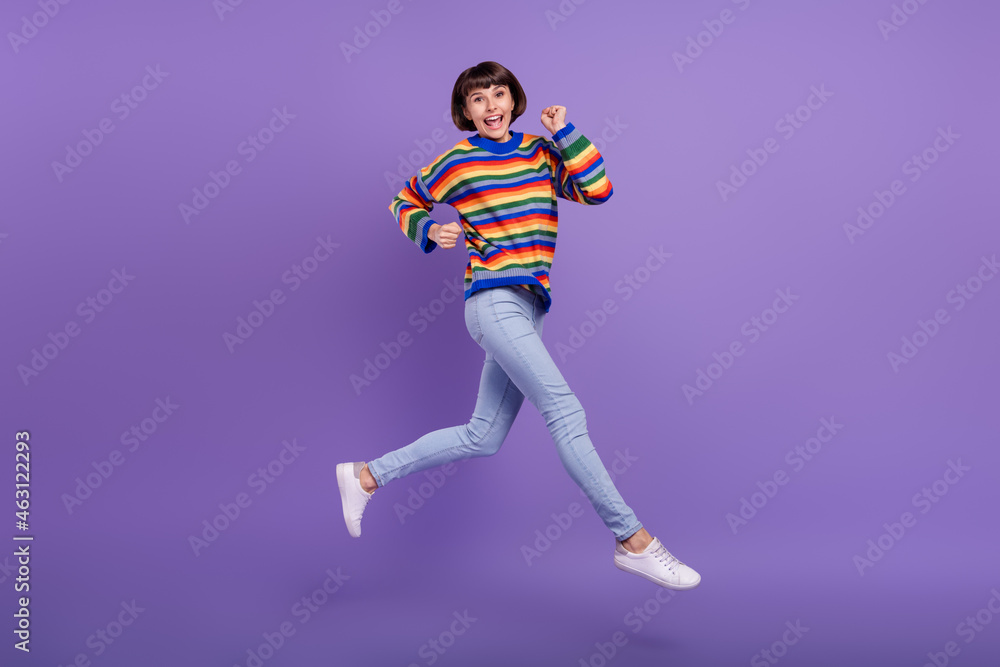 Photo of fast active lady jump hurry run wear striped pullover jeans footwear isolated violet color background Photo of fast active lady jump hurry run wear striped pullover jeans footwear isolated violet color background